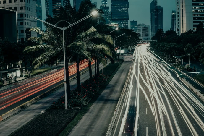 a city street filled with lots of traffic next to tall buildings